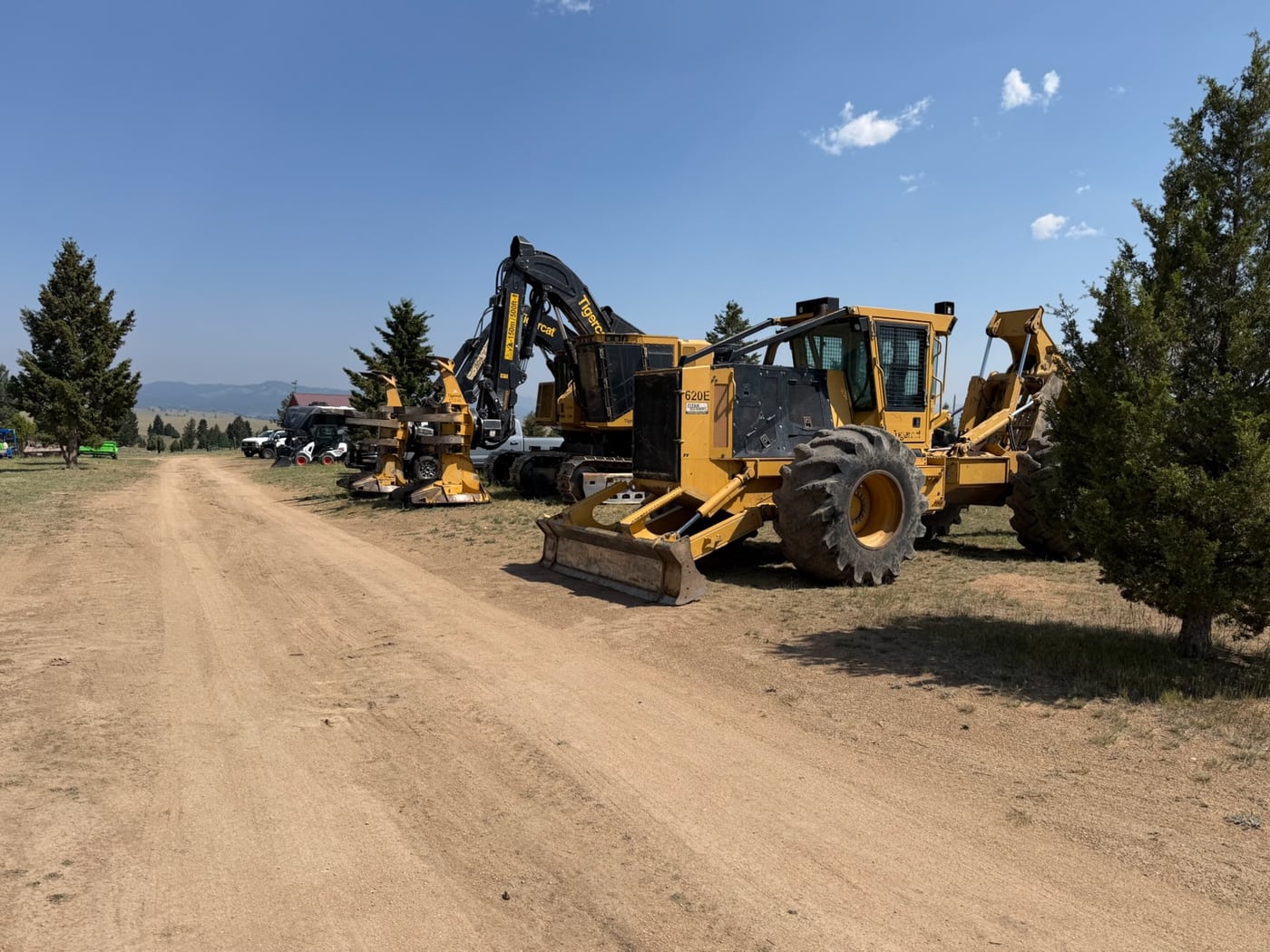 Over The Top's Tigercat forestry fleet — skidder, feller-buncher and mulcher — staged on a Montana land-clearing job